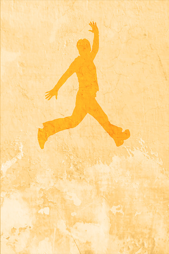 One  young happy carefree joyful bouncy man silhouette jumping with joy soaring high over old faded distressed golden colored over beige coloured vintage classic style cracked weathered vertical vector background.