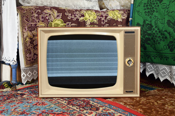 istock An old vintage TV with interference and noise on the screen in a rustic interior. 2111307913