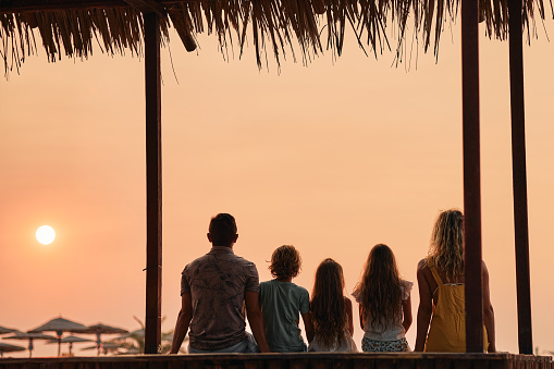 A family enjoying a tropical paradise beach during sunset.