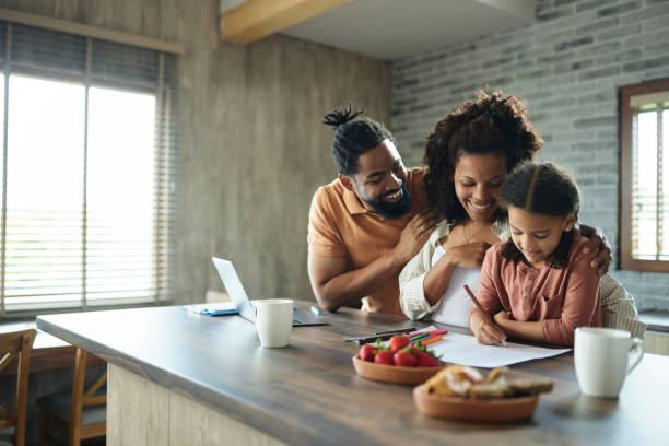 istock Happy black family enjoying while coloring at home. 2111352181