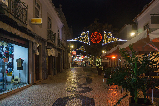 Street at night during christmas time with shops and restaurants in the historic center of Lagos, Algarve, Portugal
