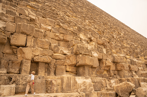 Female photographer in vacation standing with photo camera in front of the great pyramids. Egypt, Cairo - Giza