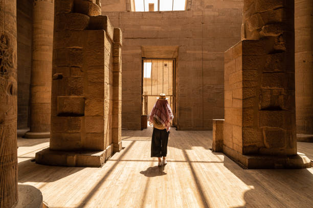 Mulher que caminha no templo de Philae aka templo de Isis em Aswan Egito, ilha de Agilkia - foto de acervo