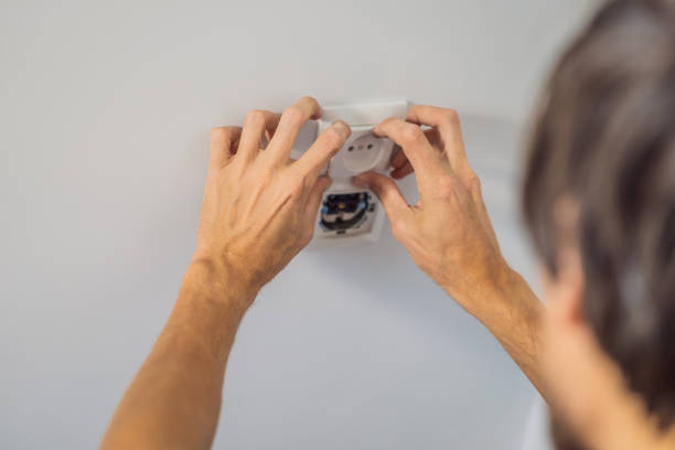 istock Master electrician installs a socket in the house 2111380299
