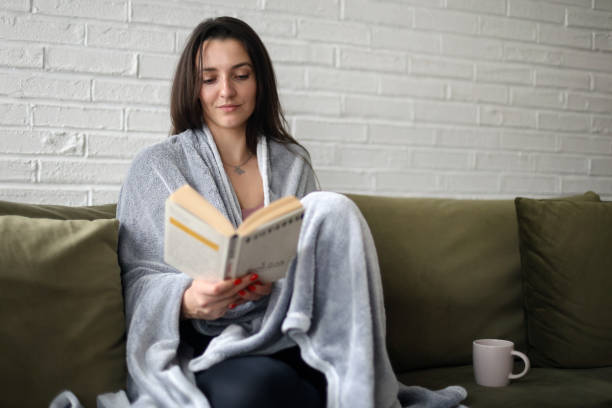 istock Young woman reading a book 2111394450