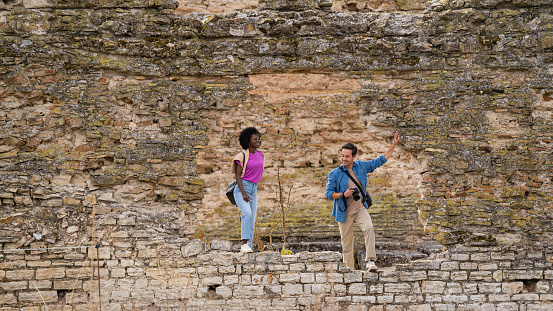 Tourist couple looking at a historical landmark antique roman aqueduct