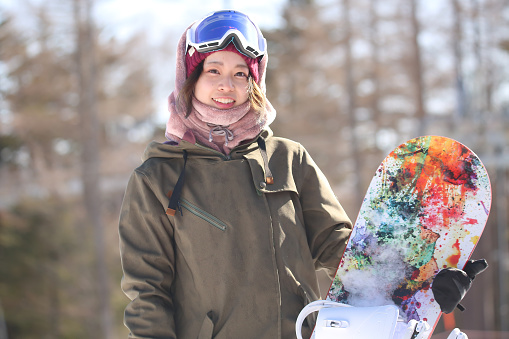 young  snowboarder  woman with smartphone at ski resort