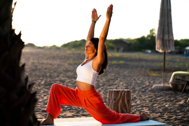 istock Woman practicing yoga during sunset on the beach 2111429057