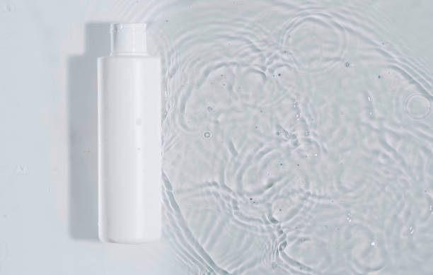istock Cosmetic moisturizer with hyaluronic acid, micellar emulsion on white water background with splashes. Mockup of cosmetic packaging 2111440652