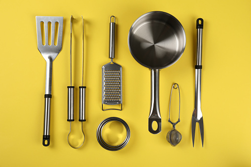 Kitchen utensil on yellow background, top view.