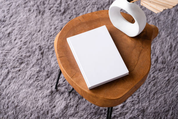 istock blank book mockup on coffee table with decorations and grey rug 2111459765