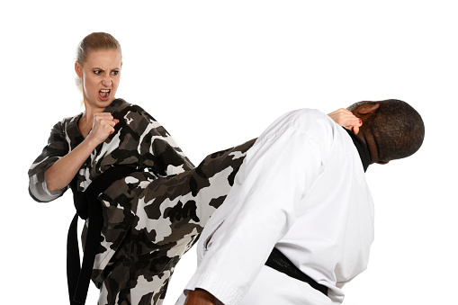 Martial artist kicking her opponent.