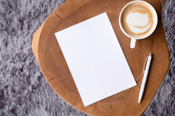 istock blank notepaper mockup on coffee table with cappuccino, pen and grey rug 2111460826