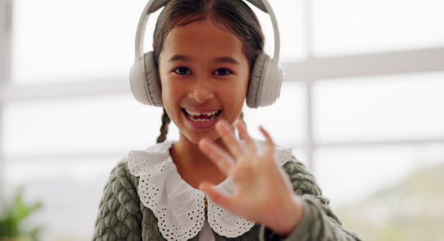 Girl child, wave and video call for online class, smile or face for education, communication or respect. Kid, portrait and headphones with greeting, kindness or happy for webinar, elearning or school