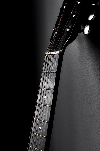 Close-up of vintage semi acoustic electric jazz guitar on black background.