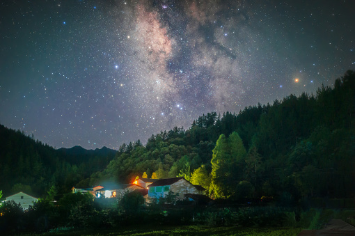 Starry sky and Milky Way in the summer mountains and villages