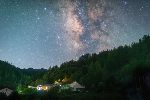 Starry sky and Milky Way in the summer mountains and villages