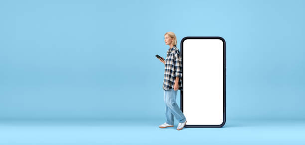 istock Smiling woman with smartphone in hand, mock up blank display 2111494979
