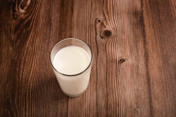 istock Milk glass isolated on wooden background. Copy space. 2111498648