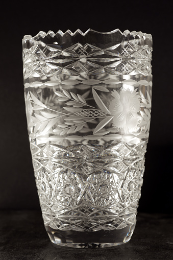 Close up of a vintage crystal vase with a black background