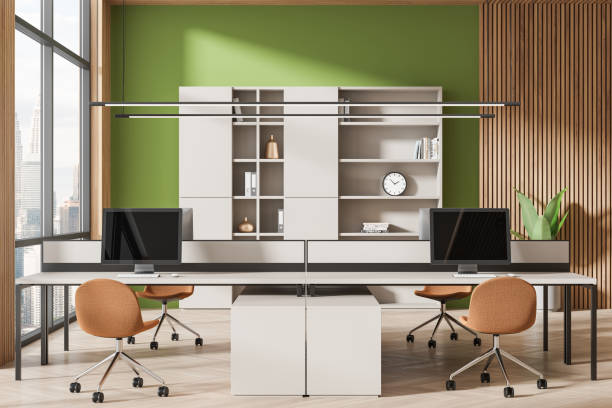 istock Colored business interior with pc monitors on table, shelf near panoramic window 2111521107