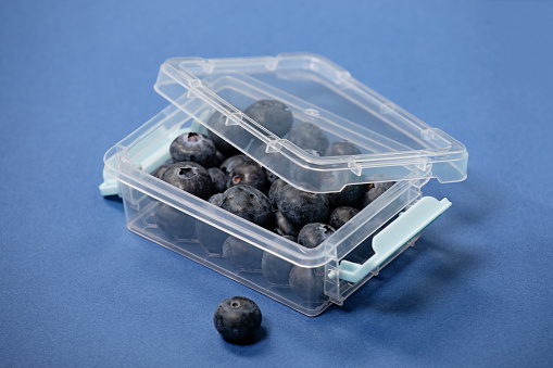 Blueberries in plastic on a colourful background as an example of sustainable recycling and healthy diet