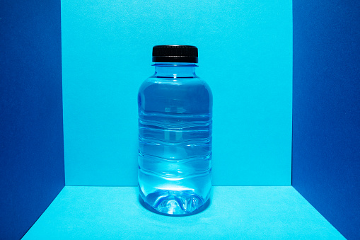 A plastic bottle of water on a colourful background as an example of sustainable recycling