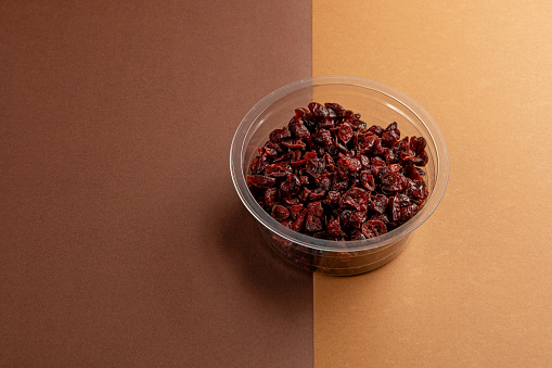 Cranberries in plastic on a colourful background as an example of sustainable recycling and healthy diet