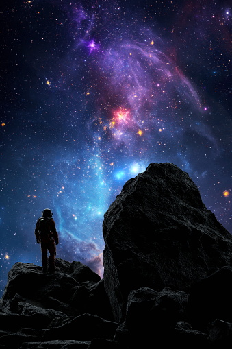 Astronaut stands atop a rocky outcrop gazing at a vibrant, star-filled galaxy above. 3d render