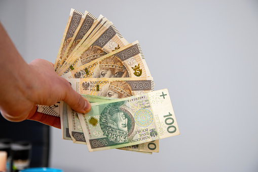A man holding Polish currency in hand