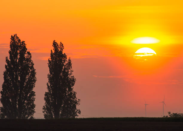 A vivid countryside sunset scene with a glowing sky
