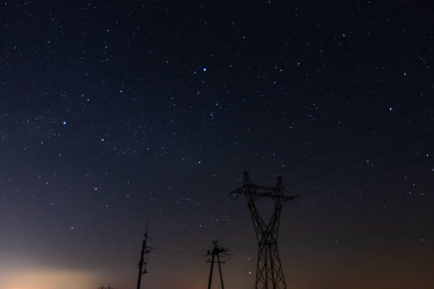istock Illuminated power lines under a starry night sky 2111567991