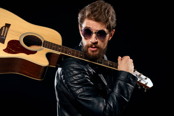 istock A man with a guitar in his hands leather jacket music performance rock star modern style dark background 2111588146