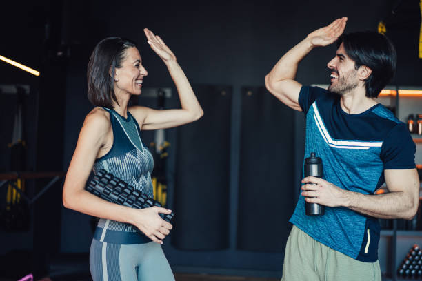 istock Couple giving each other high five after a successful workout in a gym. 2111590199