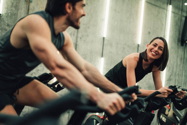 istock Couple training on exercise bike at gym. 2111590217