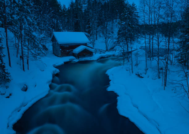 Ahja River in Taevaskoja, Estonia: Vertical winter landscape with reflections and a distant bridge in view.High quality photo