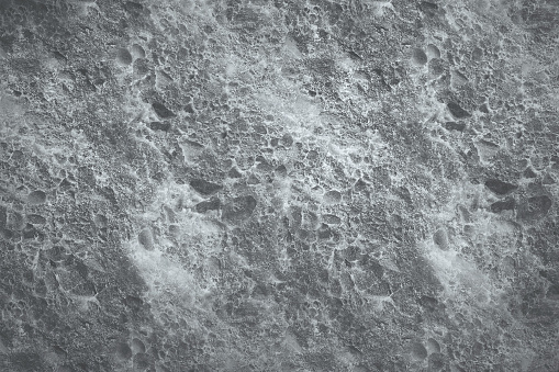 Abstract close up view of moon surface texture on grey surface background.