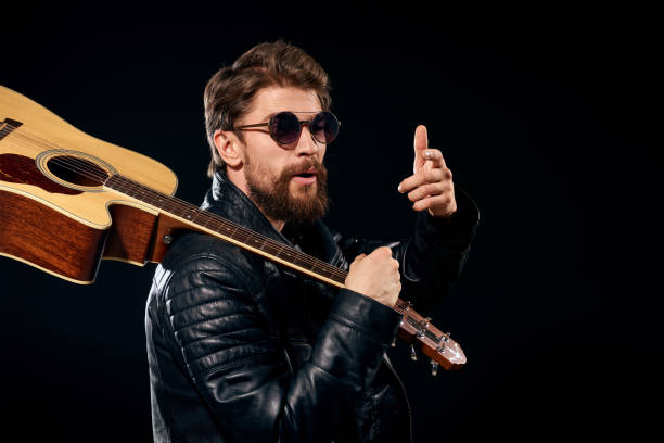 istock A man with a guitar in his hands leather jacket music performance rock star modern style dark background 2111611724