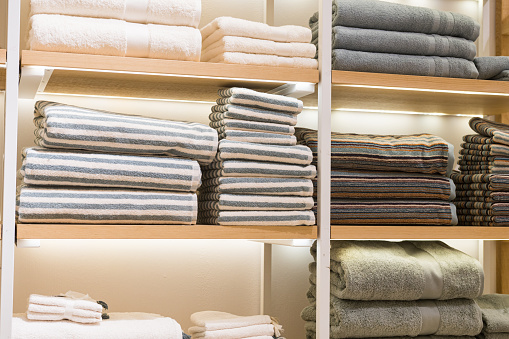 Neatly folded white and striped towels displayed on store shelves