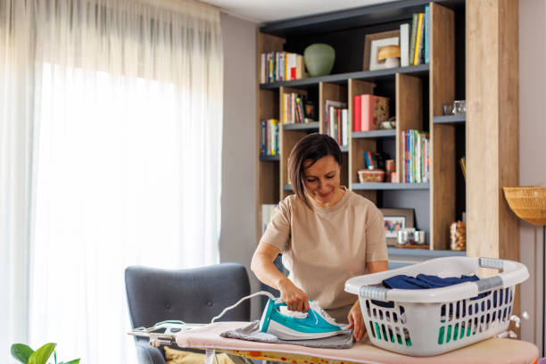 istock Female Maid Ironing Clothes 2111619486