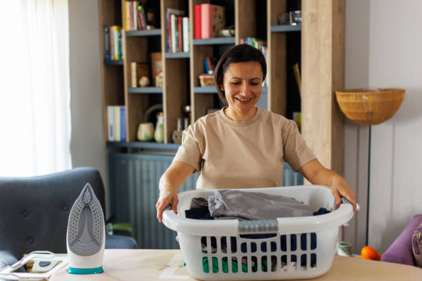 istock Female maid Holding Laundry Basket With Washed Clothes 2111619489