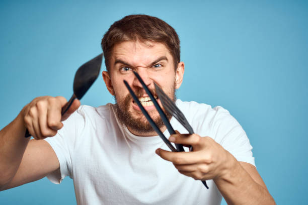 istock Bearded man with tools for cooking on a blue background and a white T-shirt shovel 2111624260