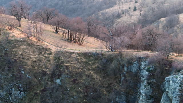 Mountain biker riding single track on narrow mountain 
ridge