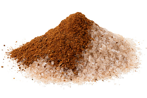 Heap of cinnamon sugar with a splash of ground cinnamon isolated on white.