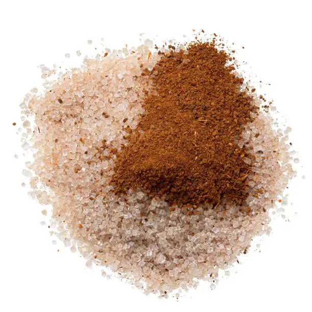 Heap of cinnamon sugar with a splash of ground cinnamon isolated on white. Top view.