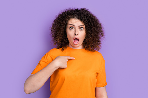 Photo of shocked impressed lady dressed orange t-shirt pointing finger herself open mouth isolated violet color background.