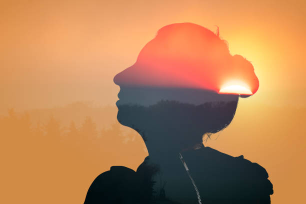 istock Woman in profile looking upwards on a setting sun background, double exposure energy, relaxation, wellbeing 2111673960