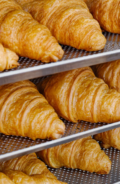istock Fresh croissants on a steel kitchen rack 2111687588