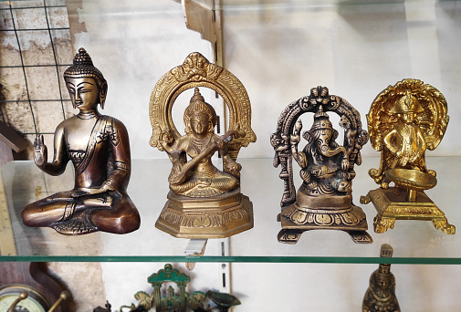 Decorative metal figurines of Buddha in a meditative pose on  shop window