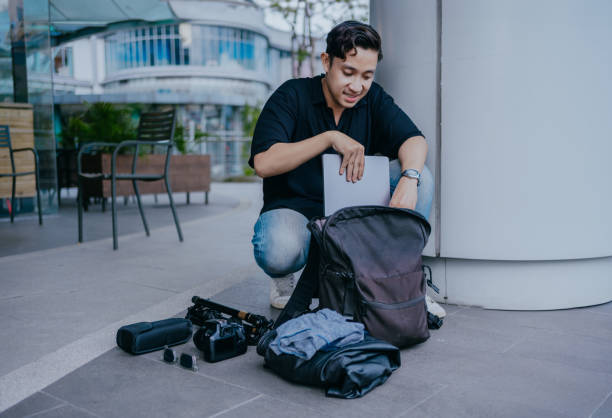istock Asian man is packing for a trip. 2111690241